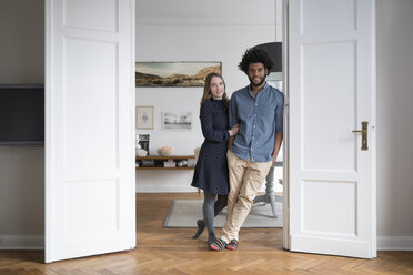 Smiling couple at home standing in door frame - SBOF00380