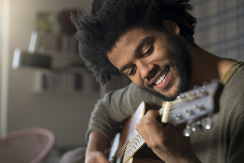 Lächelnder Mann spielt Gitarre, lizenzfreies Stockfoto