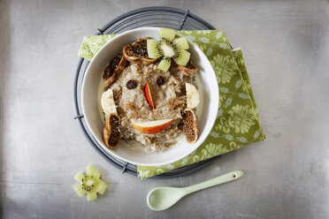 Schale mit Porridge, garniert mit Apfel, Banane, Kiwi, Rosinen und Feigen - EVGF03214