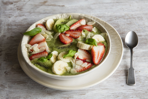 Smoothie Bowl mit Erdbeeren, Banane, Kiwi und Mandelsplittern, lizenzfreies Stockfoto