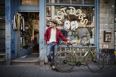 Deutschland, Hamburg, St. Pauli, Mann mit Fahrrad wartet vor einem Vintage-Laden - RORF00824