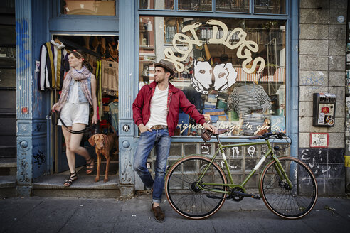 Deutschland, Hamburg, St. Pauli, Mann mit Fahrrad wartet vor einem Vintage-Laden, Frau mit Hund kommt heraus - RORF00825