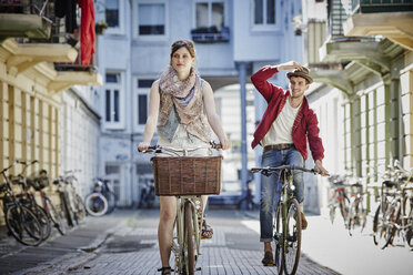 Germany, Hamburg, St. Pauli, Couple exploring the city on their bicycles - RORF00828