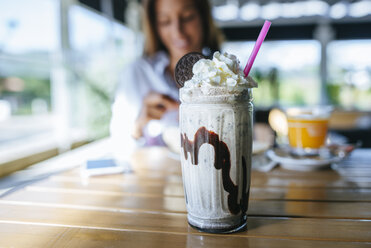 Glas Schokoladenmilchshake mit Sahne auf dem Tisch - KIJF01447