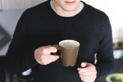 Mann mit Tasse Kaffee in der Küche, Teilansicht - FMOF00255