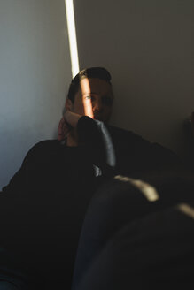 Mann versteckt sich im Schatten seines Zimmers zu Hause - FMOF00264