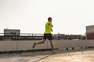 Young man running on parking level - UUF10613