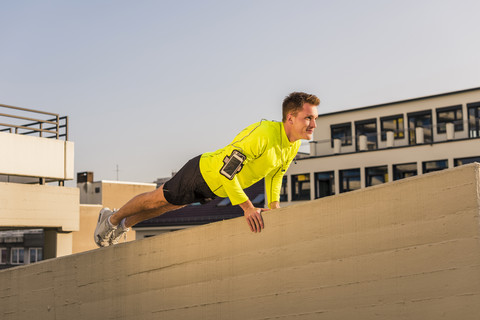 Junger Sportler macht Liegestütze auf dem Parkdeck, lizenzfreies Stockfoto