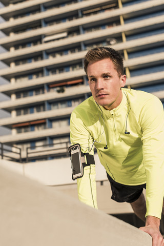 Junger Sportler macht Liegestütze auf dem Parkdeck, lizenzfreies Stockfoto