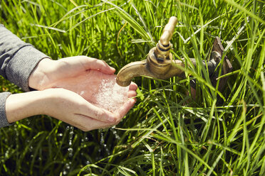 Hände einer jungen Frau, die Wasser aus einem Brunnen trinkt, Nahaufnahme - SRYF00477