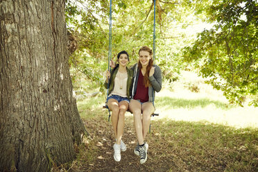 Two best friends sitting together on a swing - SRYF00494