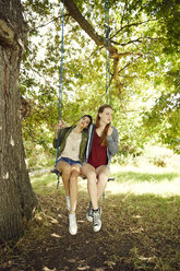 Two best friends sitting together on a swing - SRYF00495