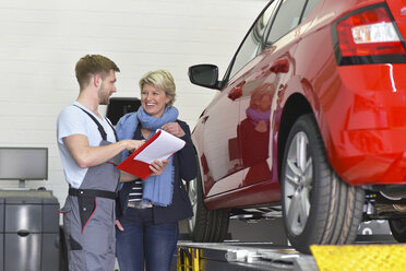 Automechaniker mit Kunde in der Werkstatt am Auto - LYF00692