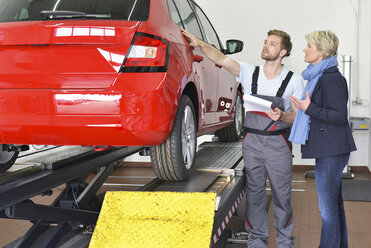 Automechaniker mit Kunde in der Werkstatt am Auto - LYF00694