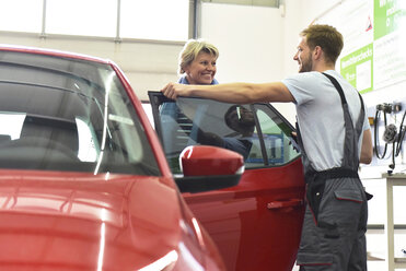 Automechaniker mit Kunde in der Werkstatt am Auto - LYF00695