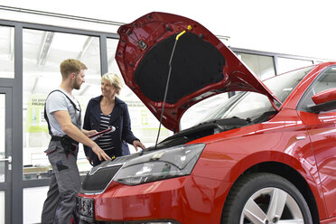 Automechaniker mit Kunde in der Werkstatt am Auto - LYF00696