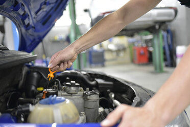 Automechaniker in einer Werkstatt bei der Kontrolle des Motoröls - LYF00712