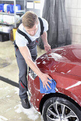 Mann reinigt Auto in einer Autowaschanlage - LYF00731