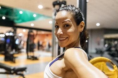 Lächelnde Frau nach dem Training im Fitnessstudio - MGOF03267