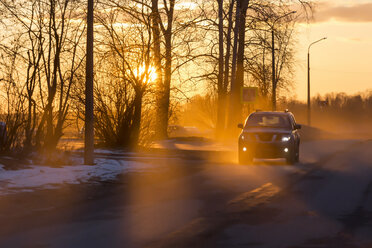 Car on road in winter at sunset - KNTF00844