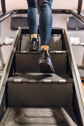 Close-up of woman training in gym with a stairs machine - MGOF03274