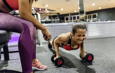 Frau mit ihrem Trainer beim Training im Fitnessstudio - MGOF03319