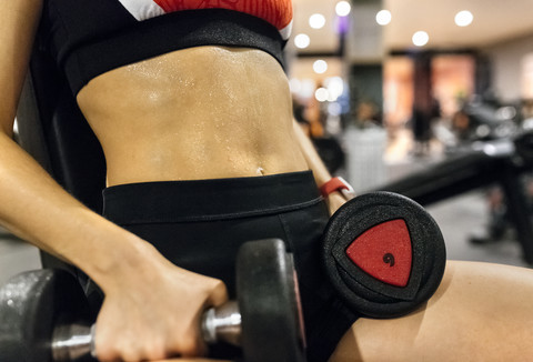 Nahaufnahme einer Frau, die in einem Fitnessstudio Hanteln hebt, lizenzfreies Stockfoto