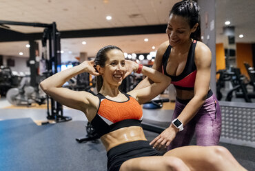 Frau mit ihrem Trainer beim Training im Fitnessstudio - MGOF03325