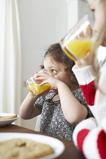 Kleine Mädchen trinken Orangensaft am Frühstückstisch - FSF00838
