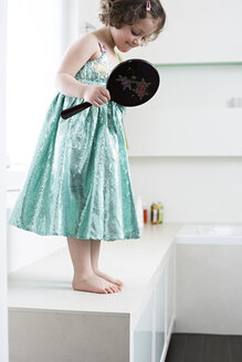 Kleines Mädchen mit Handspiegel im Badezimmer stehend und ihre Füße betrachtend - FSF00850