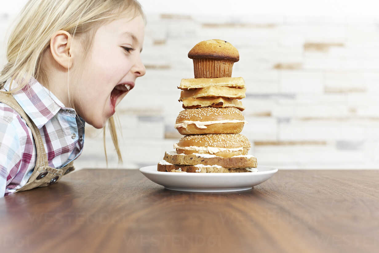 https://us.images.westend61.de/0000785960pw/hungry-little-girl-with-stack-of-baked-goods-FSF00860.jpg