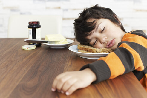 Porträt eines kleinen schlafenden Jungen am Frühstückstisch - FSF00863