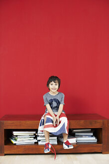 Porträt eines kleinen Jungen auf einer Anrichte sitzend - FSF00864