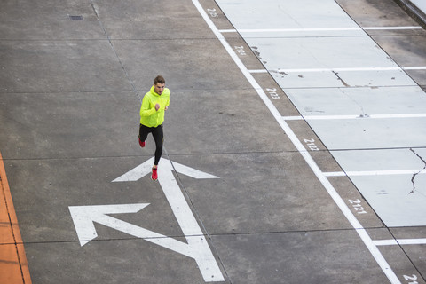 Young man running on parking level stock photo