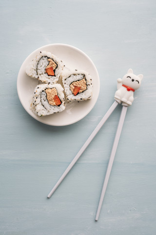 Sushi-Rollen auf einem Teller mit Stäbchen, lizenzfreies Stockfoto