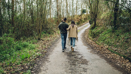 Rückansicht einer Familie beim Spaziergang im Wald im Herbst - DAPF00714