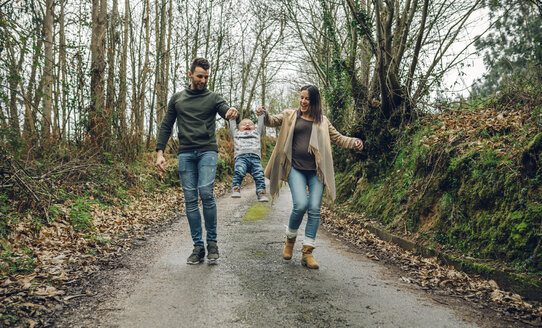 Pregnant woman having fun with family in forest in autumn - DAPF00718