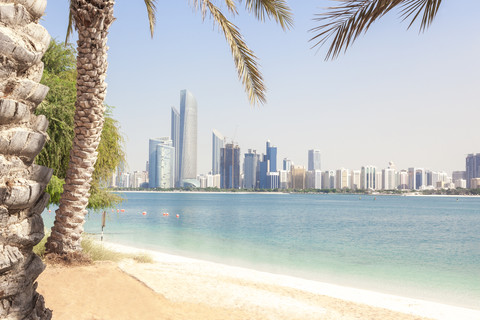 VAE, Abu Dhabi, Palme, Strand und Skyline, lizenzfreies Stockfoto