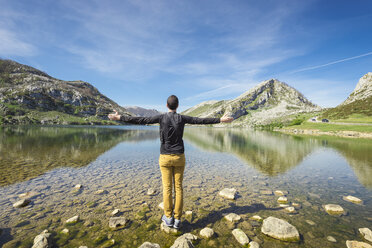 Spain, Asturias, Picos de Europa National Park, man standing with raised arms at Lakes of Covadonga - EPF00441