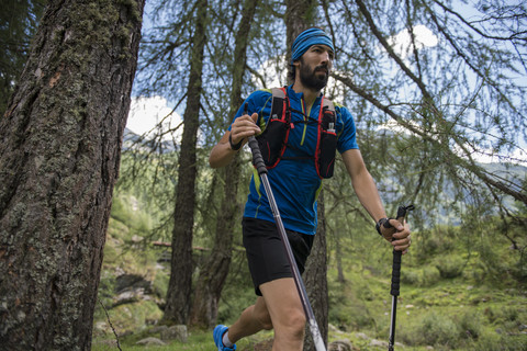 Italien, Alagna, Trailrunner unterwegs im Wald, lizenzfreies Stockfoto