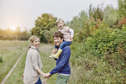 Familie auf einem Ausflug mit Vater, der seine Tochter auf den Schultern trägt, lizenzfreies Stockfoto