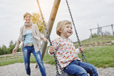 Mutter mit Tochter auf Schaukel auf Spielplatz - RORF00848