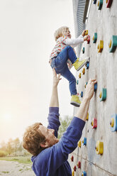 Mädchen klettert mit Unterstützung des Vaters auf eine Mauer - RORF00855