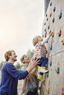 Mädchen klettert mit Unterstützung der Eltern an einer Wand - RORF00856
