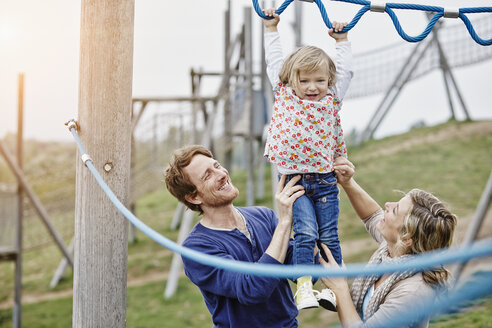 Girl on playground in climbing net supported by parents - RORF00859