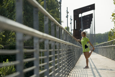 Weibliche Athletin beim Dehnen auf der Brücke - ZOCF00283