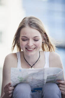 Young girl traveling alone, looking at map - MVCF00163