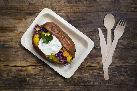 Sweet potato Kumpir withbell pepper, red cabbage, couscous, yoghurt sauce and parsley stock photo