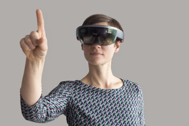 Woman wearing mixed reality smartglasses raising her hand - RBF05666