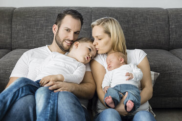 Parents with male newborn and little son relaxing at home - OJF00188